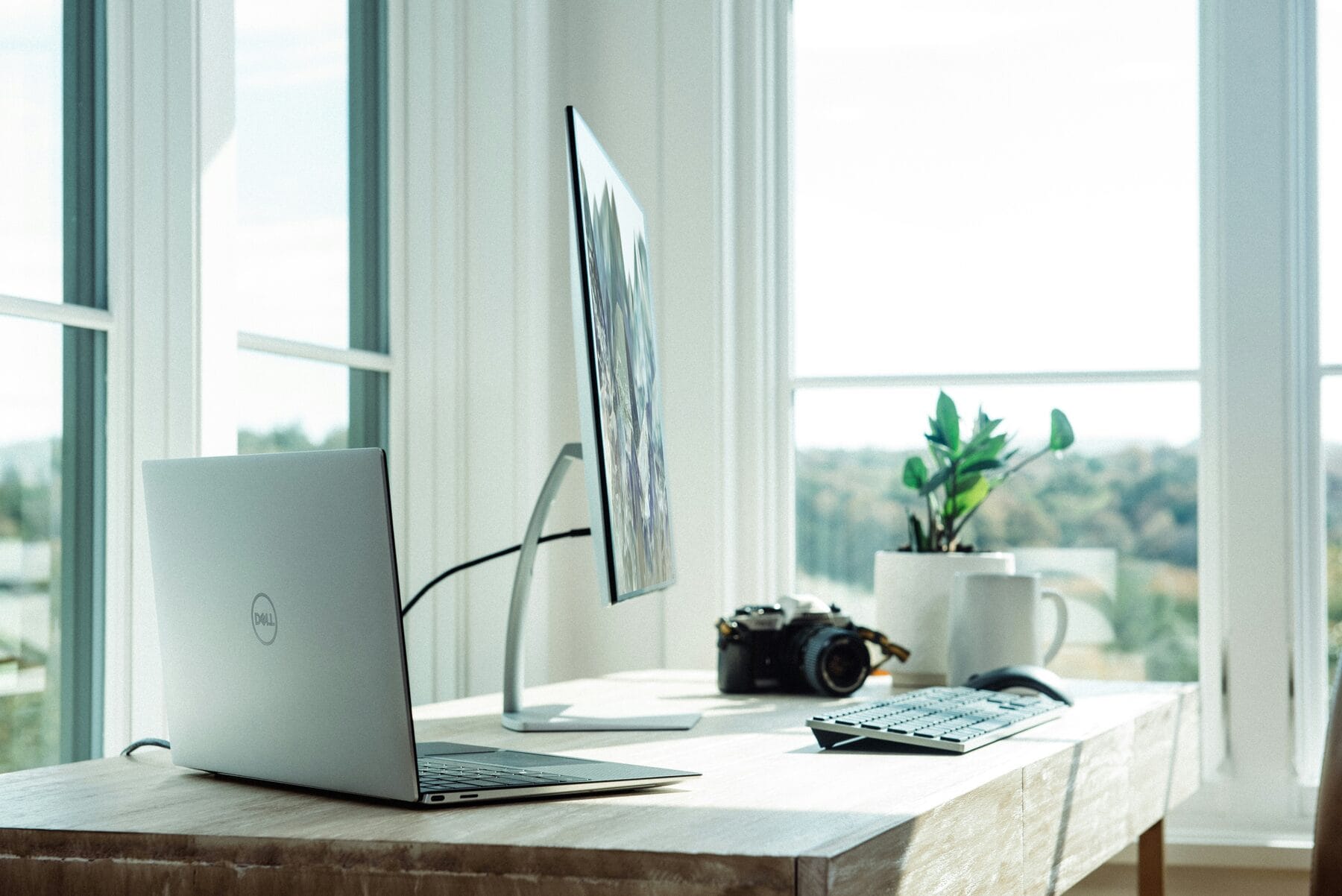 Heller Arbeitsplatz zu Hause mit Laptop und Bildschirm